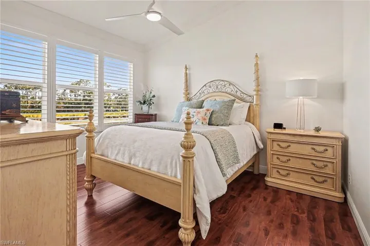Bedroom with lofted ceiling, a ceiling fan, and dark wood-type flooring