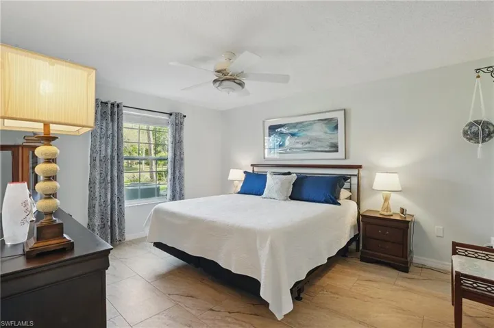 Bedroom featuring baseboards, ceiling fan, and a textured ceiling