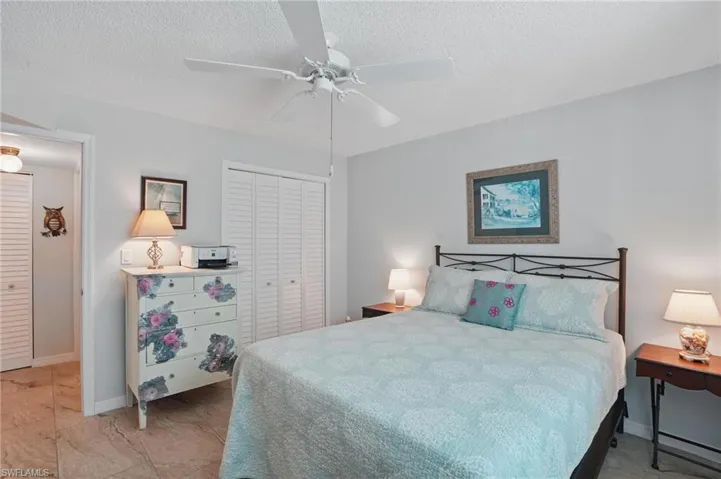 Bedroom with a closet, a ceiling fan, a textured ceiling, and baseboards
