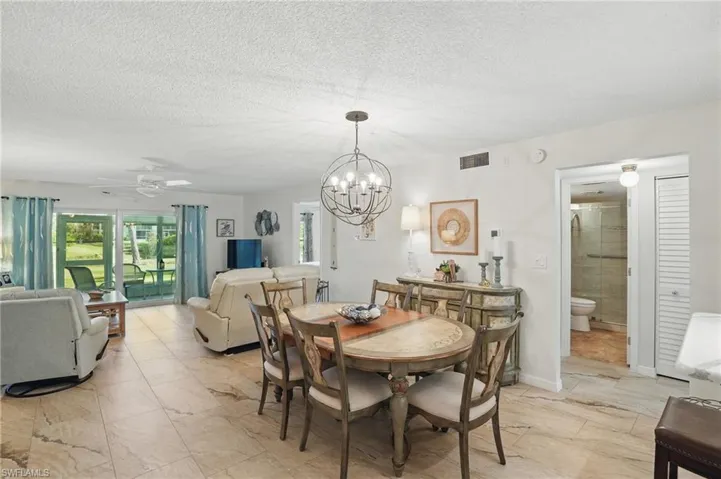 Dining area with a chandelier, a ceiling fan, and a textured ceiling