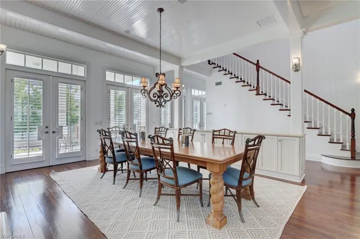 Dining room featuring light hardwood / wood-style flooring, beam ceiling, a chandelier, and french doors