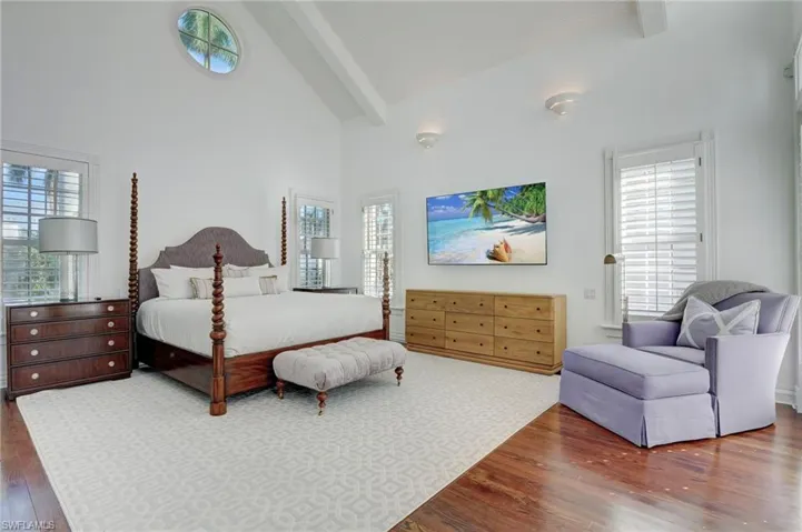 Bedroom with hardwood / wood-style floors and multiple windows