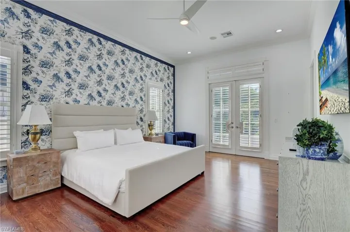 Bedroom with access to exterior, dark wood-type flooring, crown molding, ceiling fan, and french doors