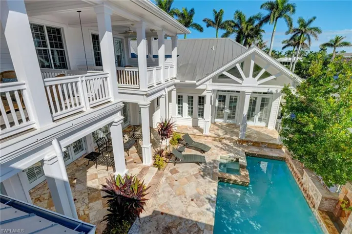 Back of property with a balcony, a patio area, and french doors