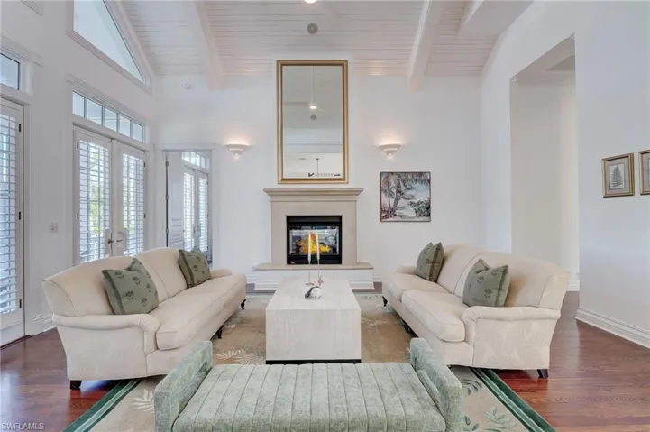 Living room with lofted ceiling with beams, wood-type flooring, and wood ceiling