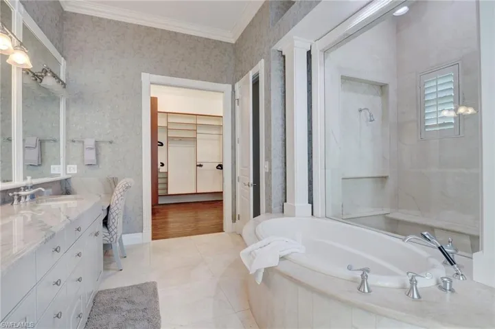 Bathroom featuring independent shower and bath, vanity, tile patterned flooring, and ornamental molding