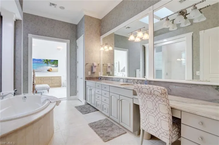 Bathroom with a bath, ornamental molding, vanity, and tile patterned floors