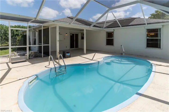 Swimming pool with a patio area and glass enclosure