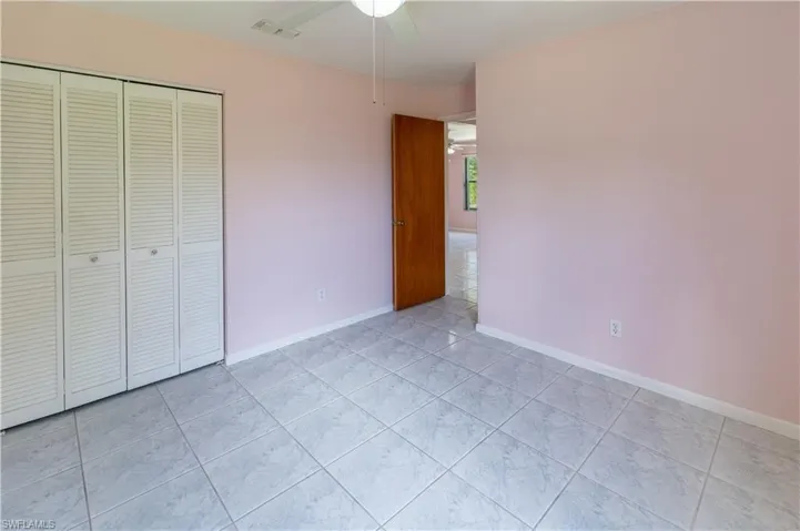Unfurnished bedroom featuring a closet, ceiling fan, and light tile patterned floors