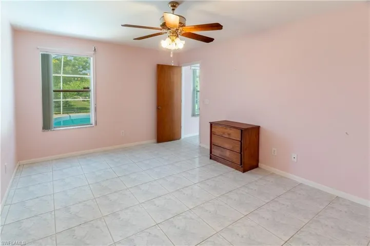 Empty room featuring ceiling fan and light tile patterned floors