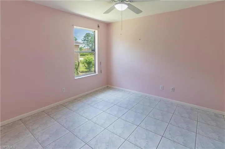 Unfurnished room with a ceiling fan and light tile patterned flooring