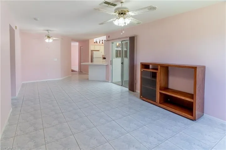 Unfurnished living room featuring a ceiling fan and light tile patterned floors