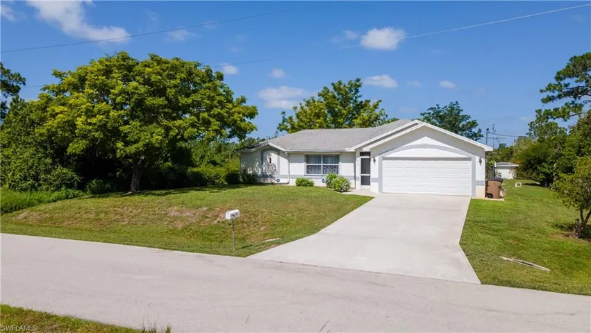 Single story home with stucco siding, concrete driveway, a garage, and a front yard