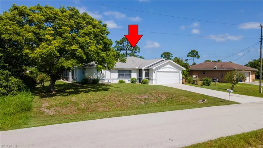Ranch-style house with a garage, concrete driveway, a front yard, and stucco siding