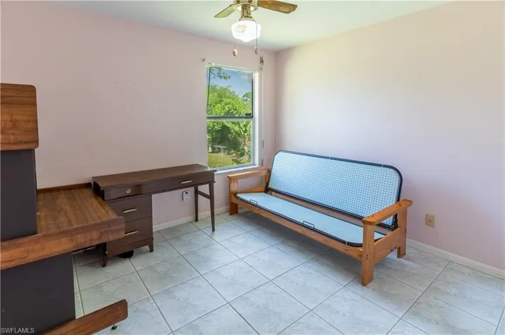Living area featuring a ceiling fan and light tile patterned flooring
