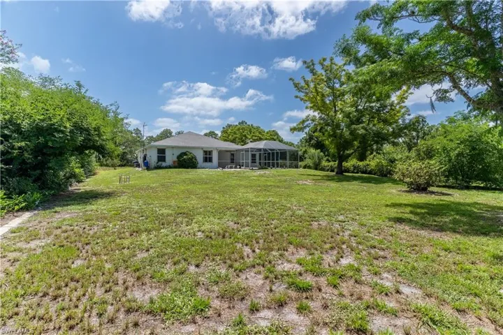 View of grassy yard with a lanai