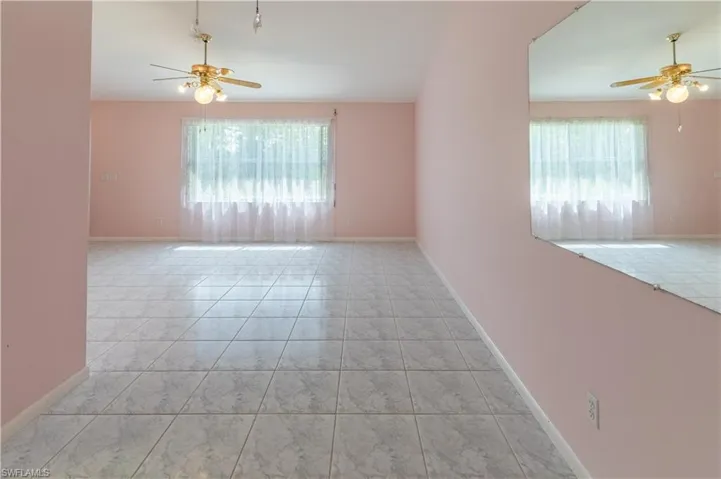 Empty room featuring a ceiling fan and tile patterned floors