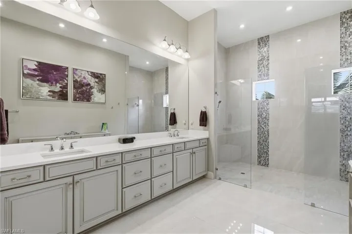 Bathroom featuring a light gray dual vanity with undermount sinks and chrome fixtures
