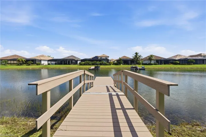 Private dock extending over a body of water with a manicured shoreline