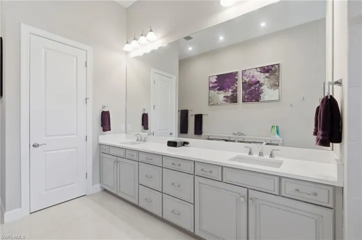 Spacious bathroom featuring a dual vanity with light gray cabinetry and white countertops