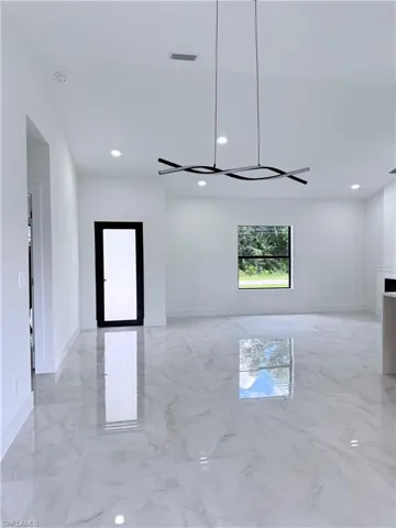 Spare room featuring light marble finish floors and recessed lighting