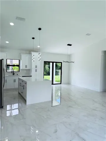 Kitchen featuring light marble finish flooring, decorative light fixtures, plenty of natural light, and recessed lighting