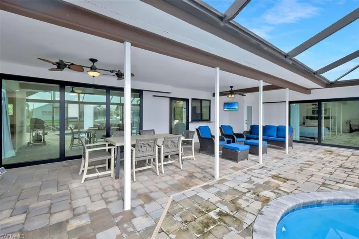 View of patio featuring outdoor dining area, a grill, a ceiling fan, a sunroom, and an outdoor hangout area
