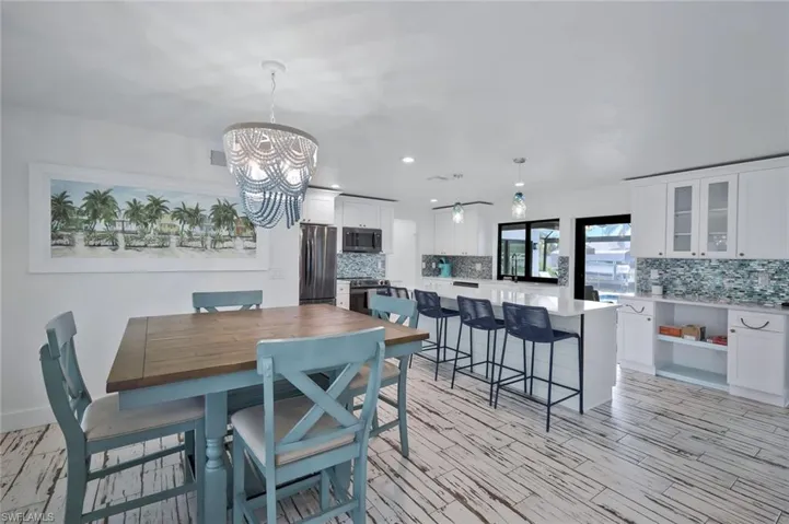Dining room with recessed lighting, light wood-style flooring, and a chandelier