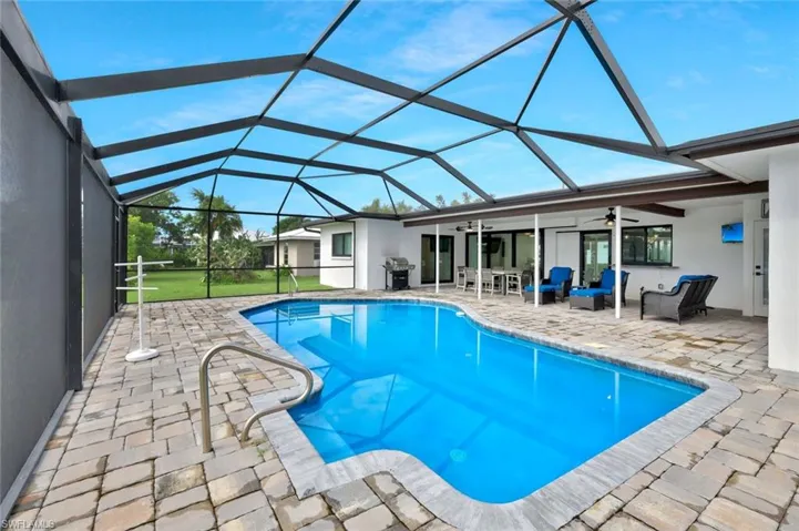 Outdoor pool featuring a ceiling fan, a patio area, a sunroom, and outdoor lounge area