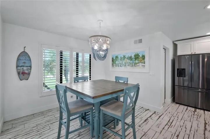 Dining space with wood tiled floors, a chandelier, and recessed lighting