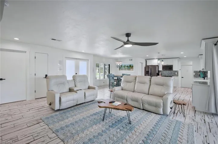 Living room featuring a ceiling fan, light wood-style floors, and recessed lighting