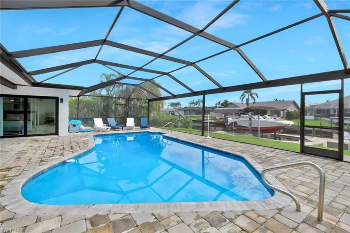 Outdoor pool with a sunroom, a lanai, a patio, and a residential view