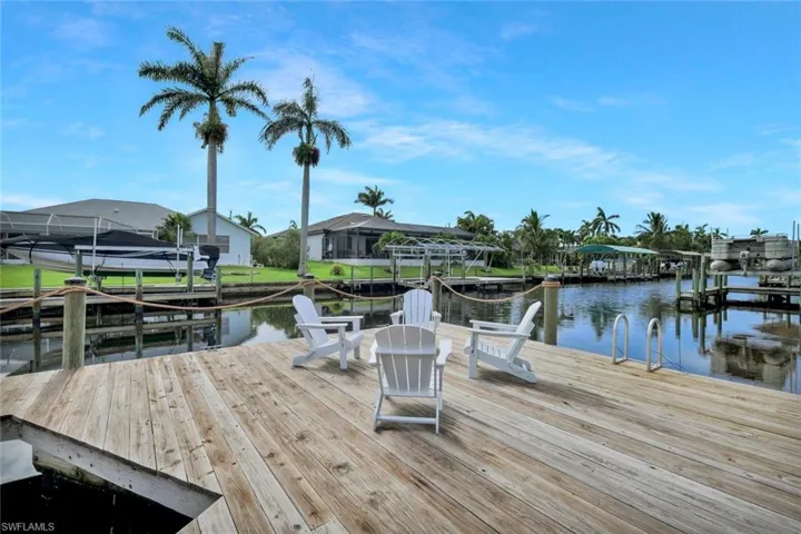Dock with boat lift, a water view, and a residential view