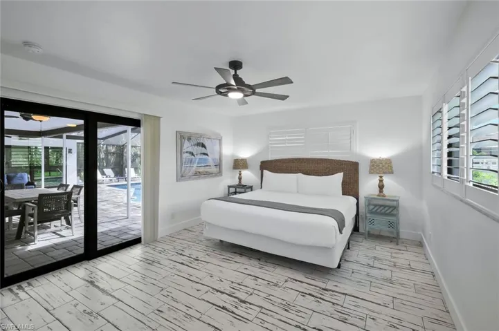 Bedroom featuring wood tiled floors, multiple windows, access to exterior, and a sunroom