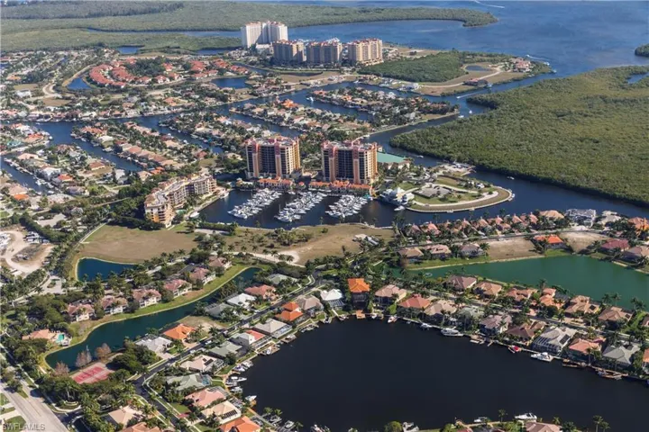 Aerial view of property and surrounding area with a nearby body of water and numerous boat docks