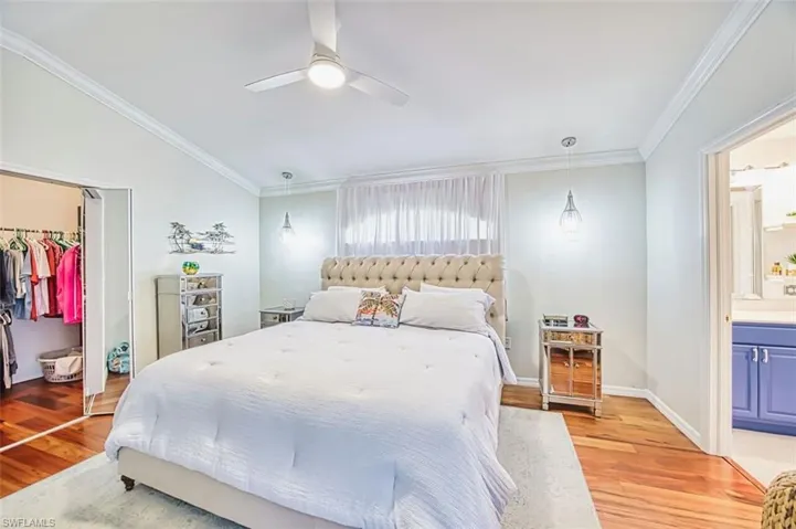 Bedroom featuring a closet, ornamental molding, ceiling fan, light wood finished floors, and ensuite bathroom