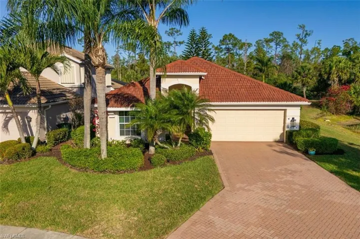 Mediterranean / spanish-style house featuring a front yard, decorative driveway, stucco siding, and a tiled roof