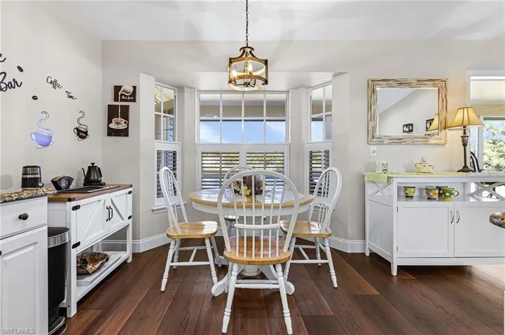 The lovely kitchen has granite countertops, white raised panel cabinets, white appliances, pantry closet off kitchen, and a breakfast, nook with plantation shutters