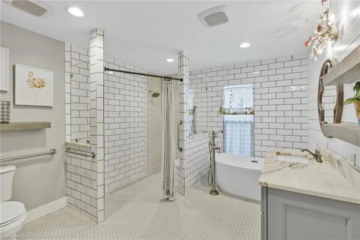 Primary Bathroom featuring walk in shower, vanity, and freestanding tub