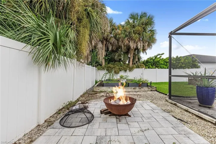 Fenced backyard with a fire pit and a patio (Fire AI generated)