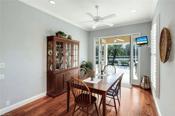 Living room with crown molding, ceiling fan, dark wood finished floors, and recessed lighting