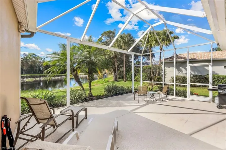 Unfurnished sunroom with a patio area, a water view, and vaulted ceiling
