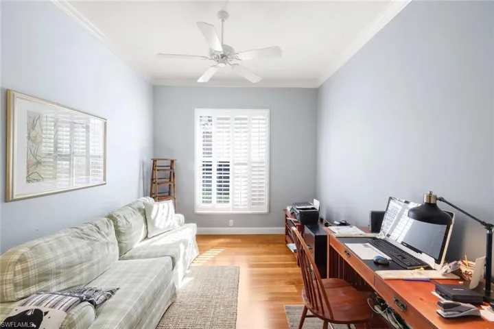 Living room featuring wood finished floors, ornamental molding, and ceiling fan