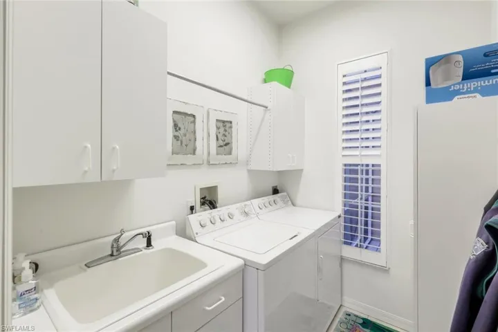 Full bathroom with wallpapered walls, walk in shower, healthy amount of natural light, double vanity, and light tile patterned floors