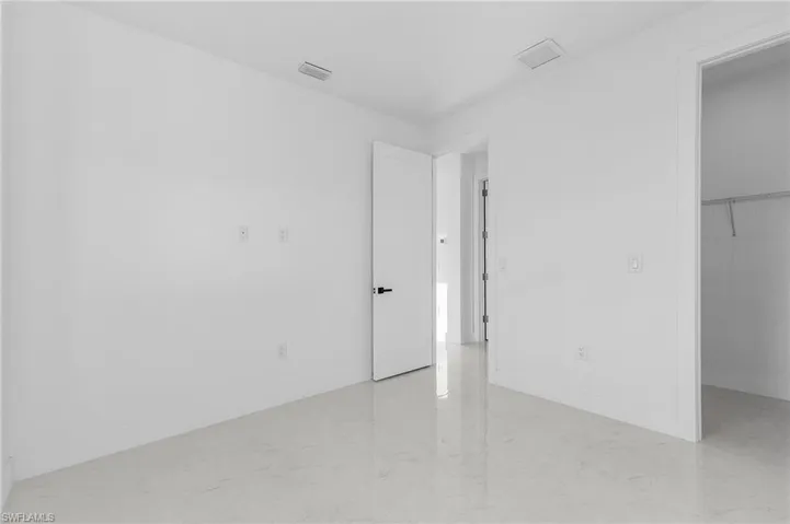 Unfurnished bedroom with a spacious closet and baseboards
