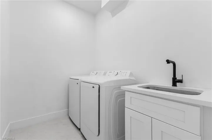 Laundry room with washer and clothes dryer and cabinet space