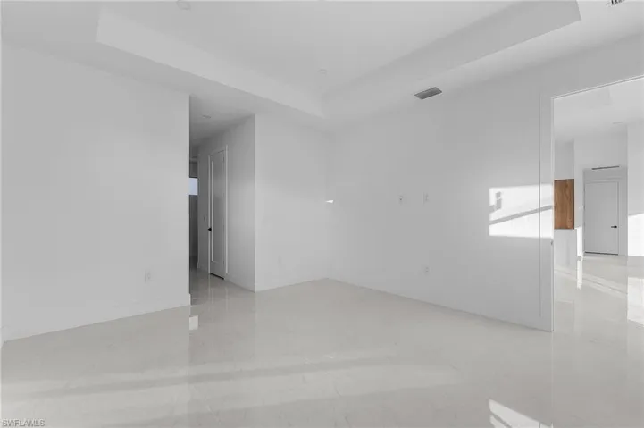 Spare room with a raised ceiling and light tile patterned flooring