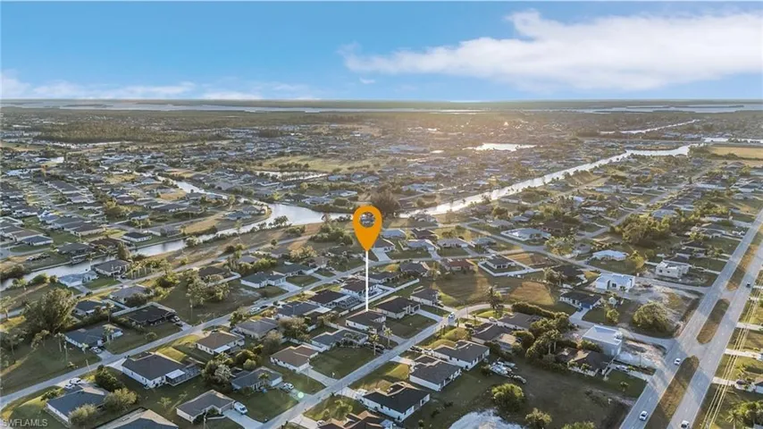Aerial view of property and surrounding area featuring nearby suburban area and a nearby body of water