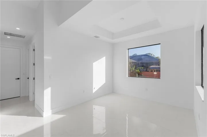 Spare room with a tray ceiling and baseboards