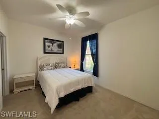 Bedroom with baseboards, a ceiling fan, and carpet